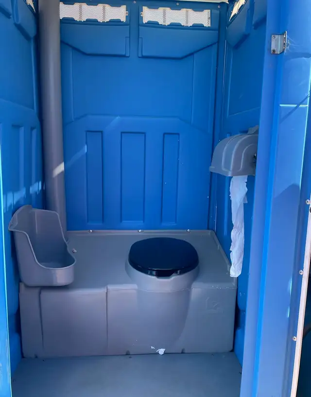 Standard porta potty interior with urinal, seat and toilet paper